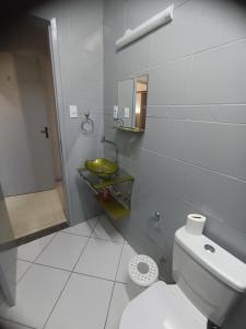 a bathroom with a white toilet and a sink at Jardim das orquideas 2 in Rio das Ostras +29 photos