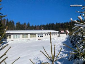 a white building with snow on the ground at Harrachov 624 in Harrachov