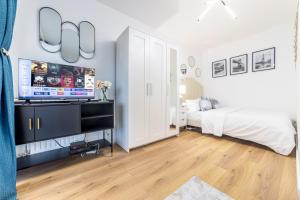 een slaapkamer met een bed en een flatscreen-tv bij Appartement en face gare d'Evry - Proche Paris & Disney - Easy check in - Arrivée autonome -Place de parking privative - Wifi in Évry-les-Châteaux