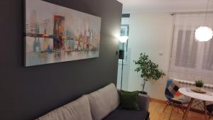 a living room with a couch and a painting on the wall at New Residence in Belgrade