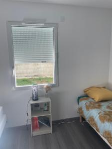 ein Schlafzimmer mit einem Fenster mit einem Blind drauf in der Unterkunft Chez Olivier et Damien in La Roche-sur-Yon