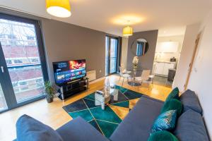 a living room with a blue couch and a tv at Superb 1 Bedroom Serviced Apartment In City Centre in Birmingham