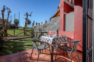 una mesa y sillas en un patio en Adosado Cigüeñas IV-Islantilla Golf en Huelva