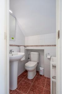 a white bathroom with a toilet and a sink at Adosado Cigüeñas IV-Islantilla Golf in Huelva