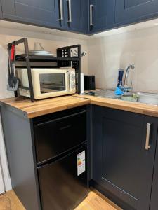 a microwave sitting on top of a kitchen counter at Mathews Den in Thamesmead