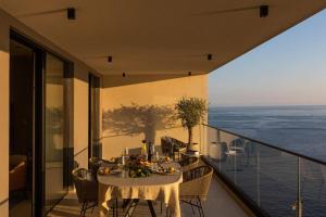 une table à manger sur un balcon avec vue sur l'océan dans l'établissement Luxury Apartment D&D with Sea Access, à Zaton