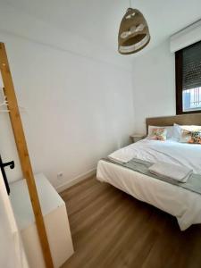 1 dormitorio con cama blanca y suelo de madera en Céntrico+nuevo APT,100% equipado, en Madrid