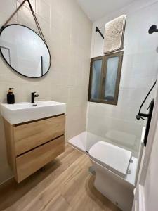 y baño con lavabo, aseo y espejo. en Céntrico+nuevo APT,100% equipado, en Madrid