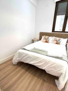 Cama grande en habitación con suelo de madera en Céntrico+nuevo APT,100% equipado, en Madrid