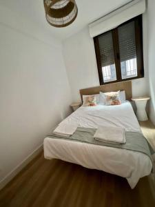 1 dormitorio con 1 cama blanca y ventana en Céntrico+nuevo APT,100% equipado, en Madrid