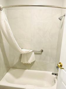 ラ・ポルテにあるGarden Suitesのバスルーム(白いバスタブ、トイレ付)