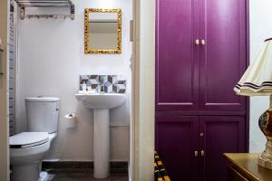 a bathroom with a purple cabinet and a toilet at Casa Zepeda in Atlixco