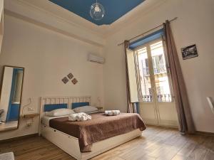 um quarto com uma cama e uma grande janela em Teatro Del Sole Maqueda em Palermo