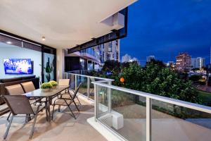 balcón con mesa, sillas y vistas a la ciudad en Circle on Cavill - Level 5 - Sleeps 8 - Wow Stay, en Gold Coast