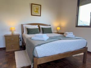 ein Schlafzimmer mit einem Bett mit Handtüchern darauf in der Unterkunft Pereira's house - Mountain & Sea in Porto da Cruz