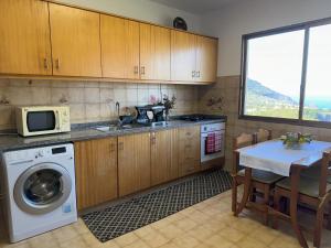 ポルト・ダ・クルースにあるPereira's house - Mountain & Seaのキッチン(洗濯機、テーブル付)