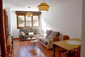 VUT PINARES DE SORIA في مولينوس ديه دويرو: غرفة معيشة مع أريكة وطاولة