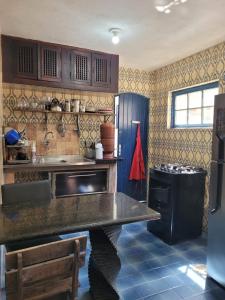 Il comprend une cuisine équipée d'un évier et d'une cuisinière. dans l'établissement Dunas 3 quartos, à Cabo Frio