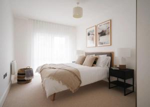 a white bedroom with a bed and a window at Luxury Apartment in London in London