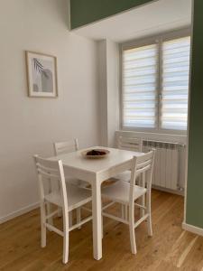un tavolo bianco con sedie in una stanza di EsseBi Home a Milano