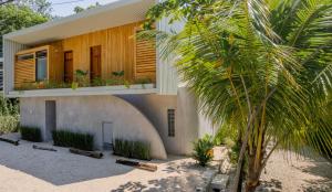 a house with a palm tree in front of it at Botanika Suites in Santa Teresa Beach