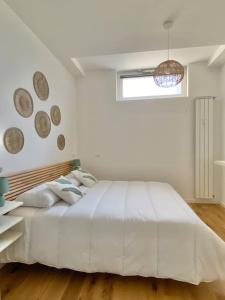 una camera bianca con un grande letto e una finestra di EsseBi Home a Milano