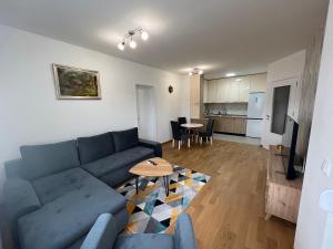 a living room with a blue couch and a table at Apartman Vista Banja Luka in Banja Luka