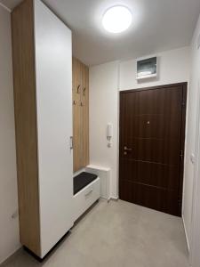 a bathroom with a brown door and a sink at Apartman Vista Banja Luka in Banja Luka