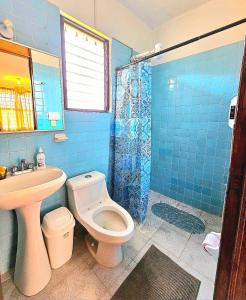 a blue tiled bathroom with a toilet and a sink at Escapada Delicias Oaxaqueñas in Santa Cruz Xoxocotlán