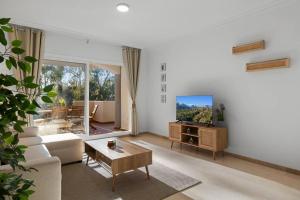 uma sala de estar com um sofá e uma televisão em Luminoso apartamento en Elviria em Marbella