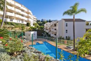 uma piscina em frente a um edifício de apartamentos em Luminoso apartamento en Elviria em Marbella