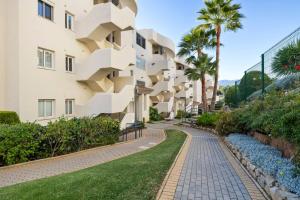 uma representação de um edifício com passadiço e palmeiras em Luminoso apartamento en Elviria em Marbella