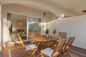 uma sala de jantar com uma mesa de madeira e cadeiras em Luminoso apartamento en Elviria em Marbella