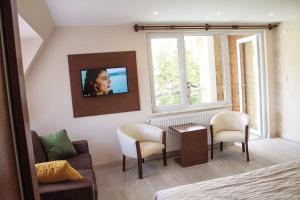 Cette chambre comprend un lit et une télévision murale. dans l'établissement Hotel Green Valley Savsat, à Savsat