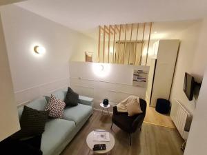 sala de estar con sofá azul y sillas en Studio chaleureux & moderne, région bruxelloise, en Asse