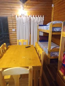 ein Esszimmer mit einem Tisch und einem Etagenbett in der Unterkunft Cabañas Misioneras in San Ignacio