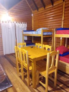 ein Esszimmer mit einem Tisch, Stühlen und Etagenbetten in der Unterkunft Cabañas Misioneras in San Ignacio