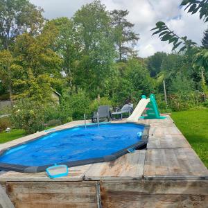 een zwembad met een glijbaan in een achtertuin bij Le val du vieux chêne in Walcourt
