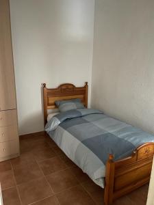 a bedroom with a wooden bed in a room at UIM Mediterraneo Pablo Iglesias Wifi in Puerto de Sagunto +4 photos