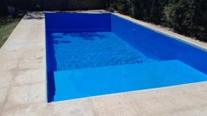 - une piscine bleue dans l'établissement LacasadelarbolTacu, à Zonda