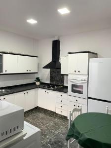 a kitchen with white cabinets and a white refrigerator at UIM Mediterraneo Pablo Iglesias Wifi in Puerto de Sagunto