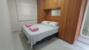 - un petit lit avec 2 oreillers roses dans l'établissement Apartamento Alto Padrão próximo Agrishow, à Ribeirão Preto