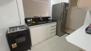 Il comprend une petite cuisine équipée d'une cuisinière et d'un réfrigérateur. dans l'établissement Apartamento Alto Padrão próximo Agrishow, à Ribeirão Preto
