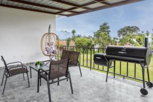 einen Grill auf einer Terrasse mit Stühlen und einem Tisch in der Unterkunft Beautiful Family Home in Boquete in Alto Boquete
