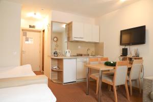 una pequeña cocina y comedor con una mesa y una habitación en Apartments Konaci Centar, en Kopaonik