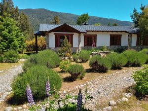 ein Garten vor einem Haus mit Pflanzen in der Unterkunft Cabañas Aldea de Montaña in Lago Puelo