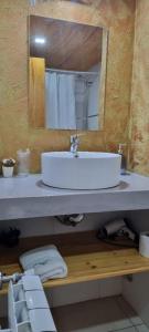 La salle de bains est pourvue d'un lavabo blanc et d'un miroir. dans l'établissement Arroyo Escondido, à Trevelín
