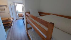 Un dormitorio con dos literas y una ventana. en Les aiguilles d'or, en L'Alpe-d'Huez