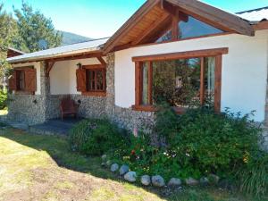 ein Steinhaus mit einem Fenster im Hof in der Unterkunft Cabañas Aldea de Montaña in Lago Puelo + 18 Fotos