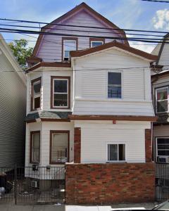 une maison blanche avec une brique rouge dans l'établissement SUITE Dreams CARROLL 11, à Paterson